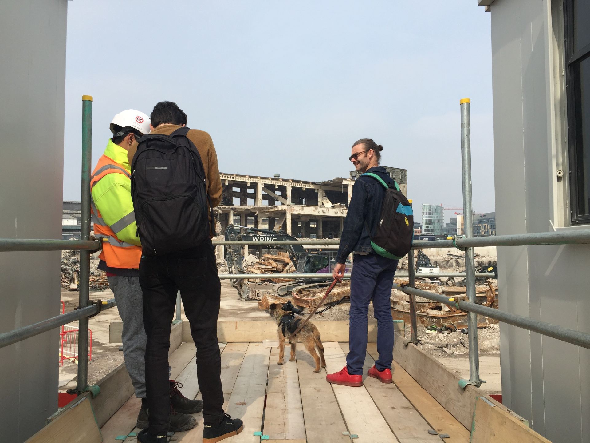 Three people and a dog at a construction site