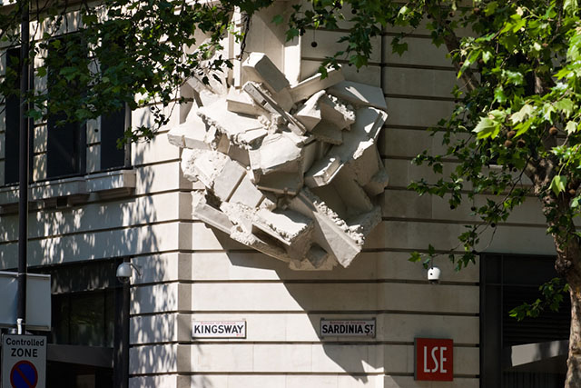 Crumbling building sculpture on corner of office block